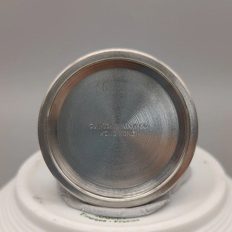 Montre vintage Clinton 25 Jewels de 1961 à mouvement manuel, cadran champagne, photographiée sur fond uni.