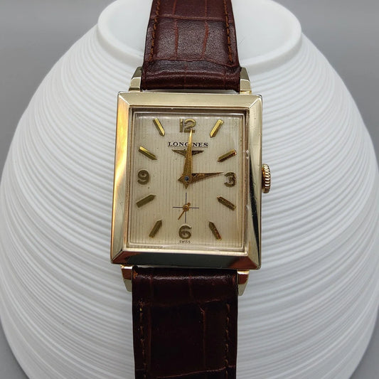 Cadran champagne détaillé d'une montre Longines Vintage Square de 1955, mouvement manuel. Élégance horlogère vintage.