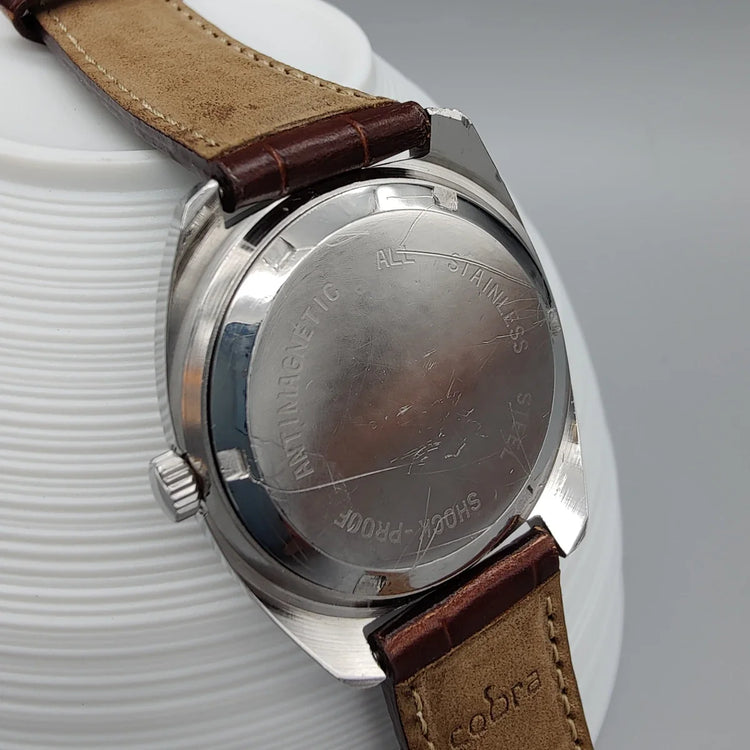 Photo d'une montre Oris Antichoc vintage 1970, cadran champagne, mouvement manuel, présentée sur fond épuré.