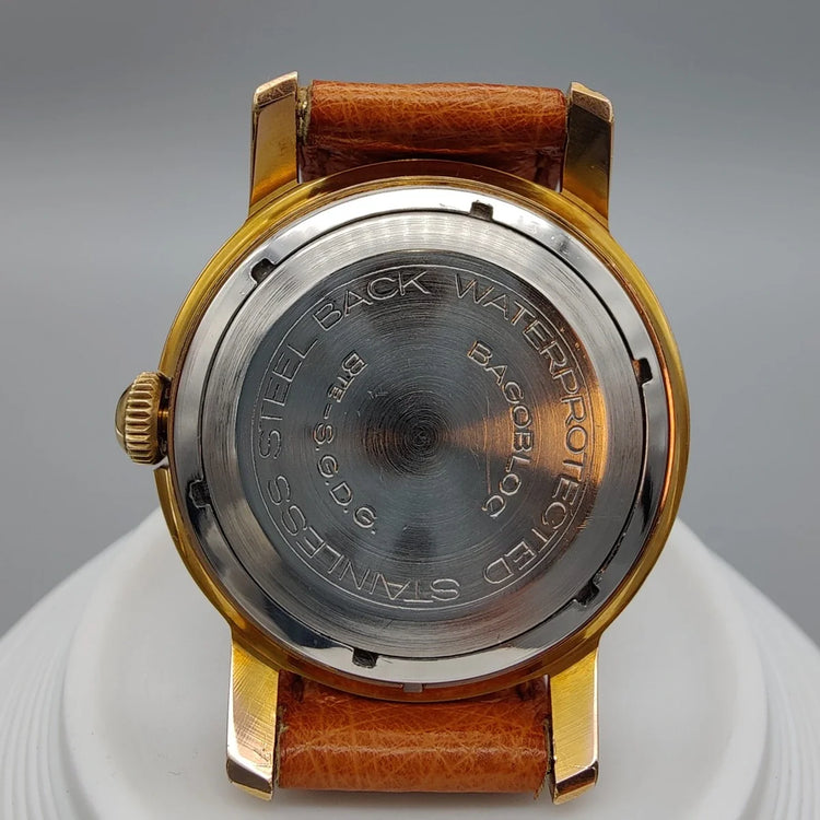 Montre vintage Regor Precision 1950, cadran crème/argenté, mouvement manuel, sur fond. Élégance intemporelle.