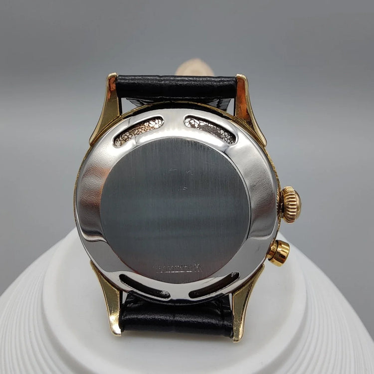 Montre vintage Vulcain Cricket de 1955 avec cadran champagne et mouvement manuel, présentée sur fond.