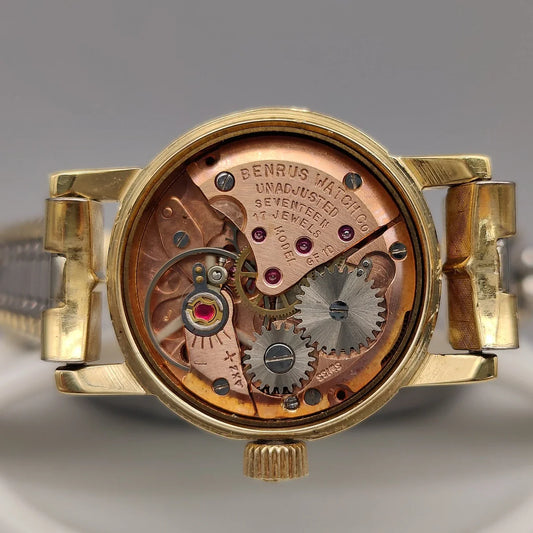 Vue détaillée du mouvement manuel d'une montre vintage Benrus Cocktail de 1955, cadran champagne.