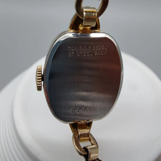 Benrus Ladies Cocktail Watch vintage 1950, mouvement manuel. Montre femme élégante sur fond blanc argenté.