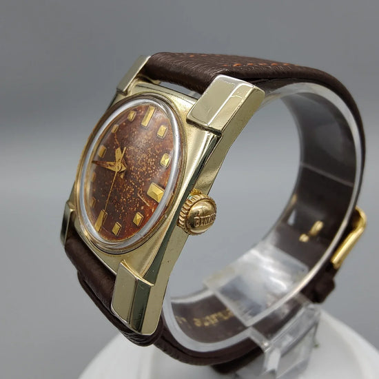 Gros plan couronne montre vintage Benrus Series 2500 (1950) avec cadran dégradé, mouvement manuel.