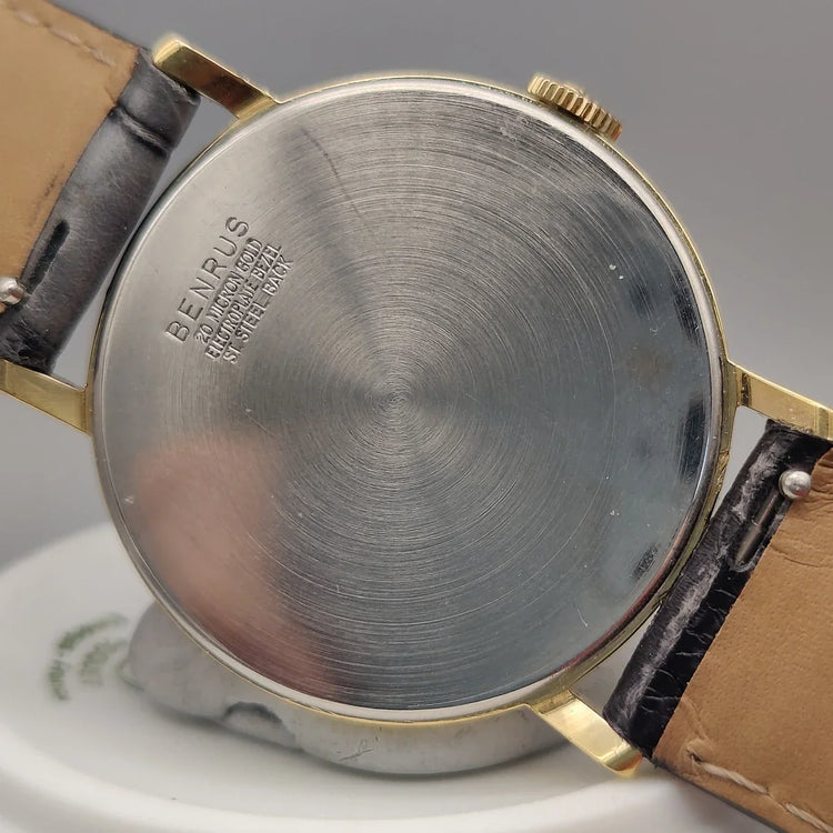 Montre vintage Benrus Shock-Absorber 1955, cadran champagne, mouvement manuel, sur fond élégant. Idéale montre femme.