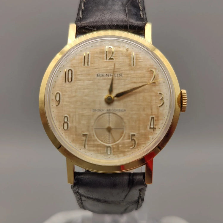 Vue de la lunette d'une montre vintage Benrus Shock-Absorber de 1955 avec cadran champagne, mouvement manuel.