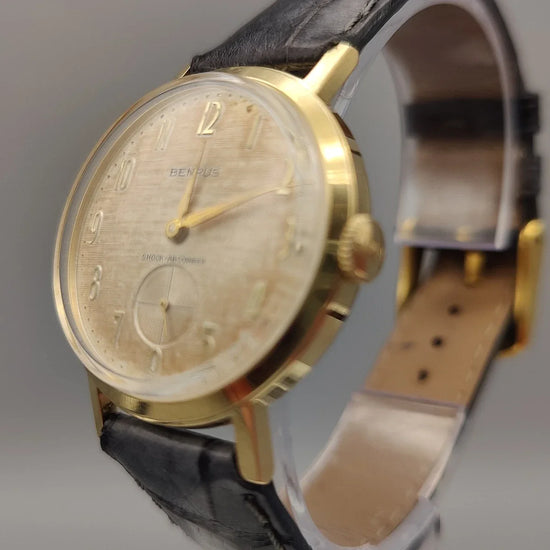Gros plan sur la couronne d'une montre vintage Benrus Shock-Absorber de 1955. Détail élégant et authentique.