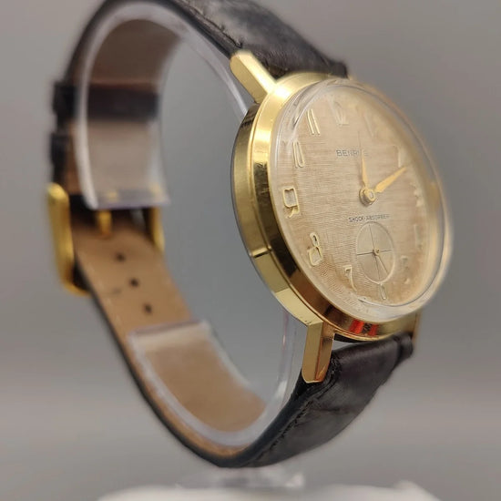 Photo de profil d'une montre vintage Benrus Shock-Absorber de 1955, cadran champagne, mouvement manuel.