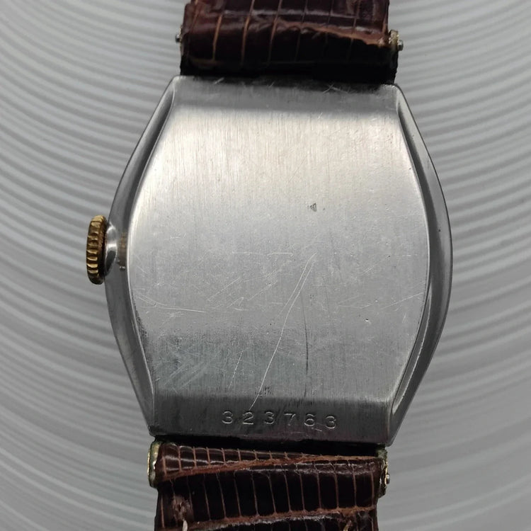 Montre Benrus Vintage Tonneau 1945, mouvement manuel, cadran champagne sur fond. Élégante montre vintage pour femme.