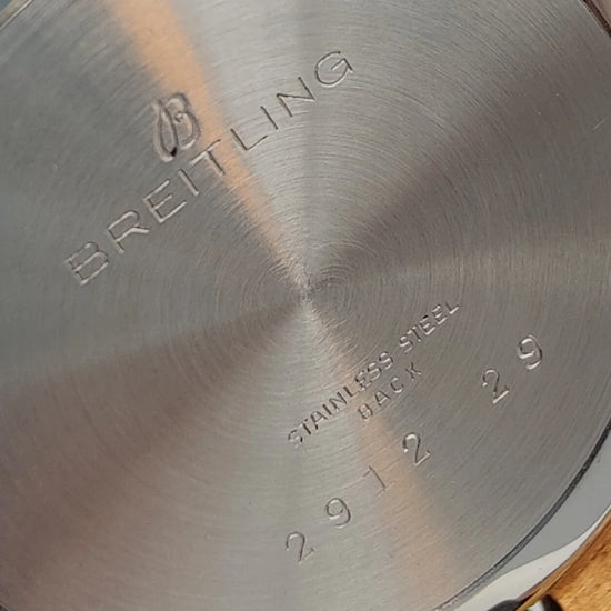 Montre Breitling Genève vintage de 1955 avec cadran champagne, mouvement manuel, présentée sur fond.