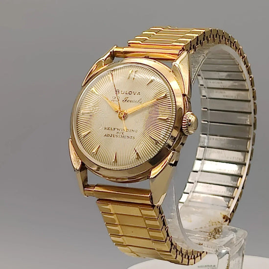 Gros plan sur la couronne cannelée d'une montre vintage Bulova 23 Jewels Self-Winding de 1955, mouvement automatique, cadran champagne.