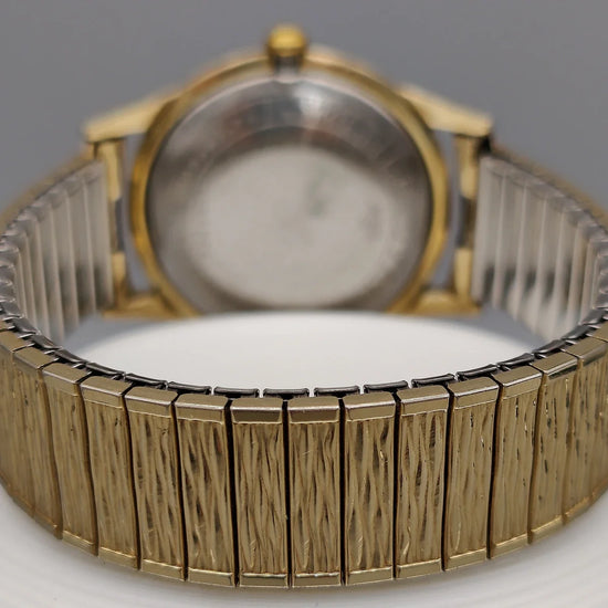 Montre vintage Bulova Classic 1958, cadran champagne, mouvement manuel. Vue détaillée sur fond.