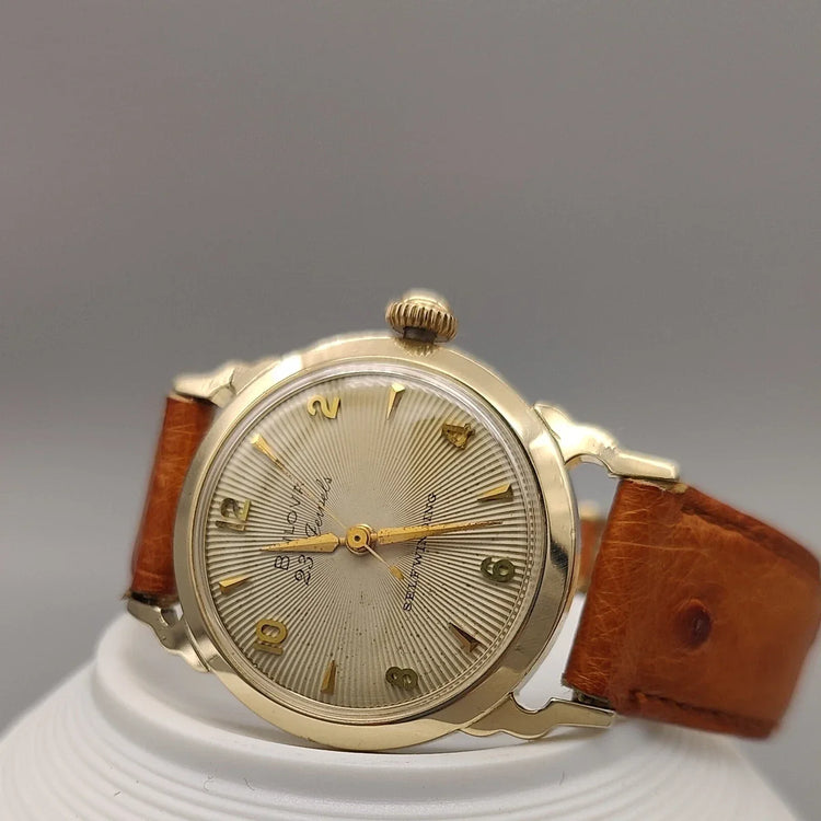Gros plan sur la lunette d'une montre vintage Bulova Selfwinding 23 Jewels de 1957 avec son cadran couleur champagne.