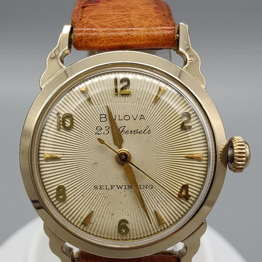 Gros plan du cadran champagne de la montre vintage automatique Bulova Selfwinding 23 Jewels datant de 1957.