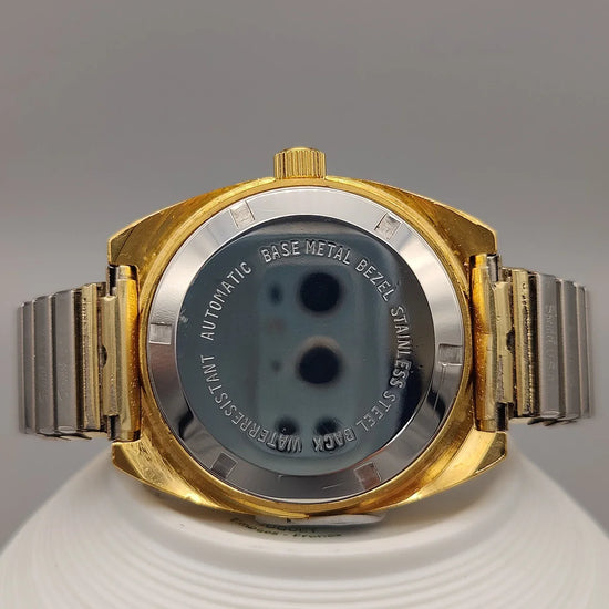 Montre vintage Clinton 25 Jewels de 1961, mouvement manuel, cadran champagne. Photo produit sur fond uni.