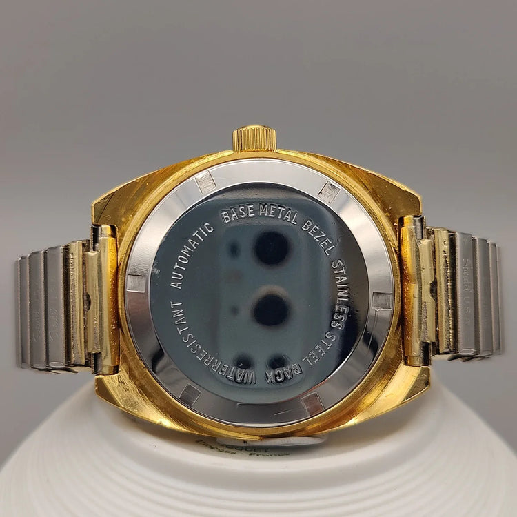Montre vintage Clinton 25 Jewels de 1961, mouvement manuel, cadran champagne. Photo produit sur fond uni.