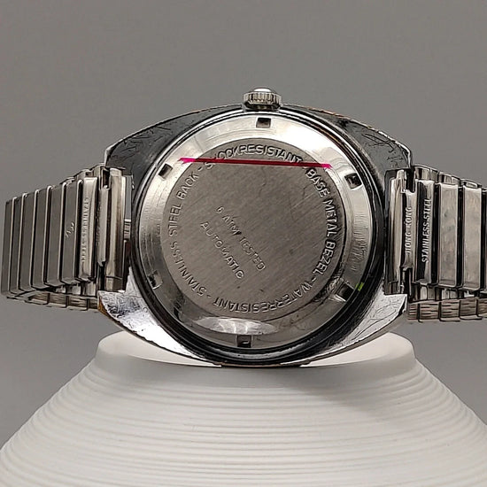 Vue de fond d'une montre automatique vintage Clinton World Timer 1972, cadran noir.