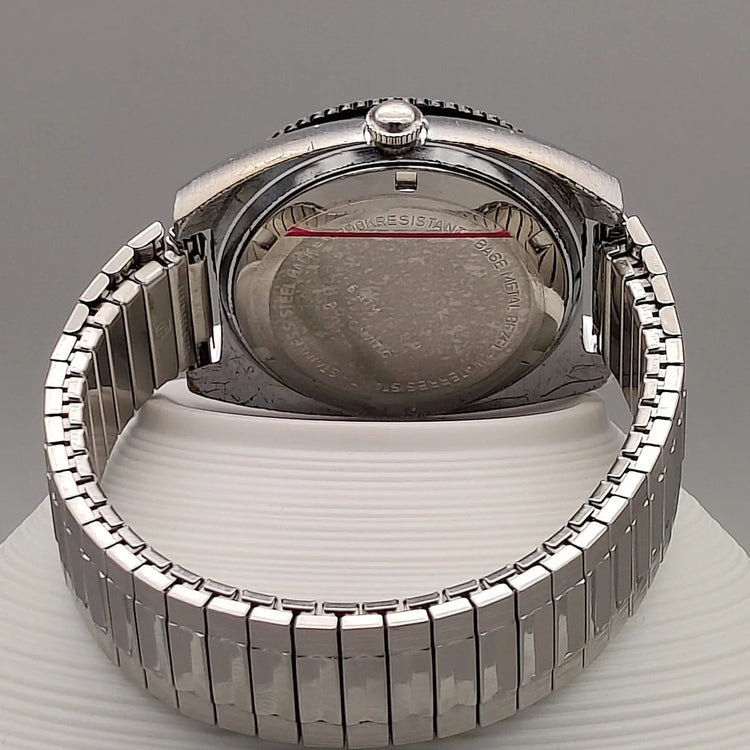 Montre vintage automatique Clinton World Timer 1972, cadran noir, mise en scène sur fond élégant.