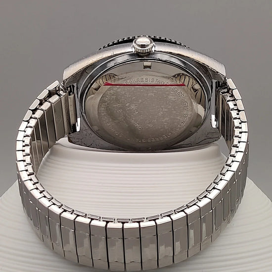 Montre vintage Clinton World Timer automatique de 1972, cadran noir, vue sur fond neutre pour collectionneurs.