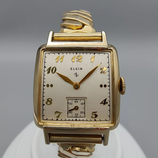 Cadran champagne d'une montre vintage Elgin Durapower de 1949, mouvement manuel. Détail élégant et authentique.