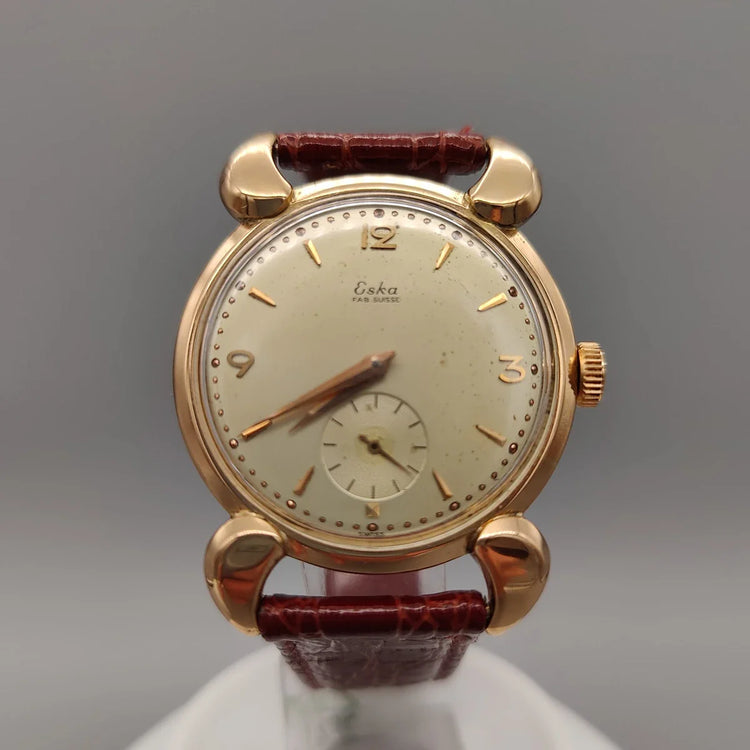 Eska Fab. Suisse 1950, montre vintage manuelle. Vue détaillée de la lunette et du cadran crème. Montre suisse authentique.