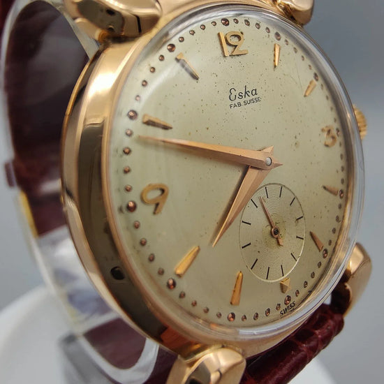 Eska Fab. Suisse 1950, montre vintage manuelle, vue rapprochée de la couronne. Élégance suisse classique.