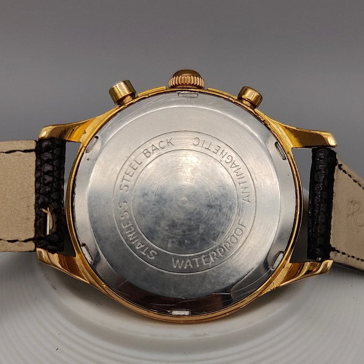 Montre vintage Kiplé Chronostop 1955 à mouvement manuel, cadran champagne. Vue de fond détaillée.