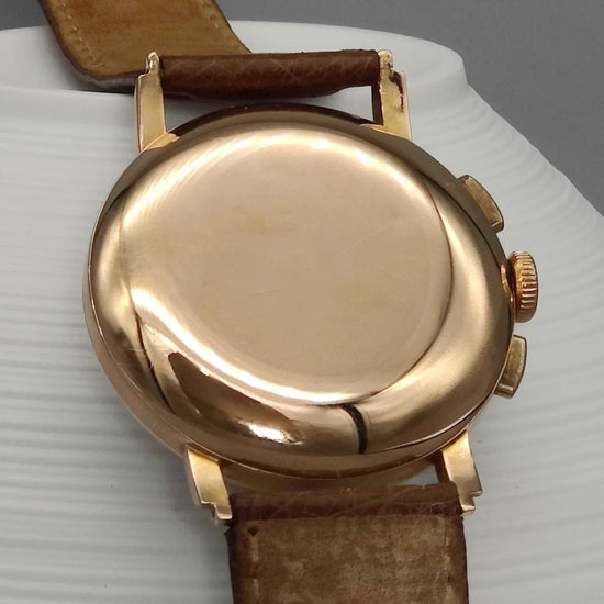 Lemania Chronographe 1955, montre vintage exceptionnelle. Vue d'ensemble sur fond élégant, cadran champagne.