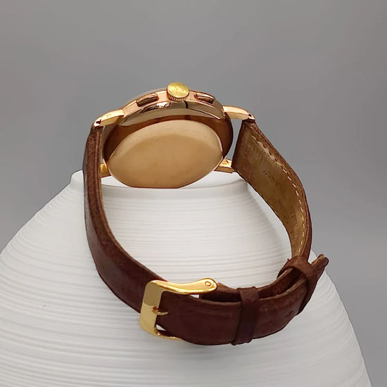 Montre vintage Lemania Chronographe 1955, cadran champagne. Mouvement manuel. Vue de fond.