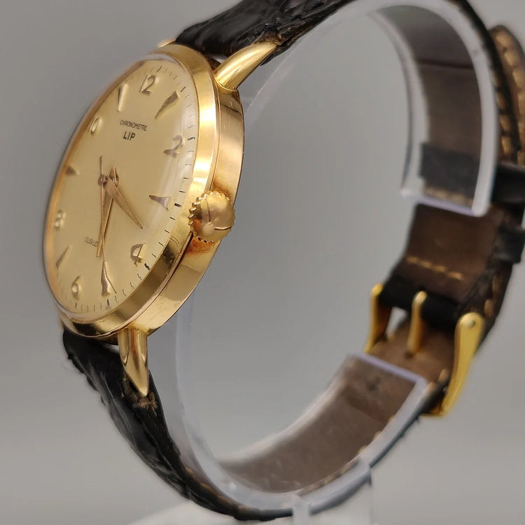 Vue détaillée de la couronne d'une montre vintage Lip Chronometre de 1955, avec son cadran champagne et mouvement manuel.