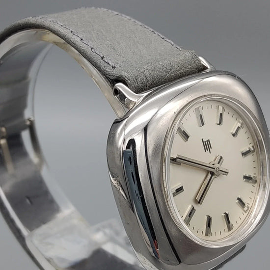 Lip TV Coussin vintage 1970, cadran crème, mouvement manuel, vue de profil. Une montre vintage élégante.