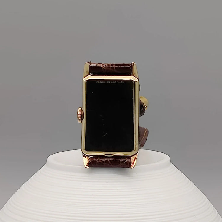 Montre Longines Art Deco Rectangular 1944, cadran champagne, mouvement manuel. Vue détaillée sur fond.