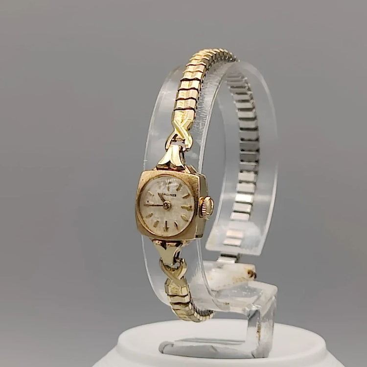 Couronne d'une montre Longines Cocktail vintage de 1961, mouvement manuel, cadran champagne. Détail élégant.