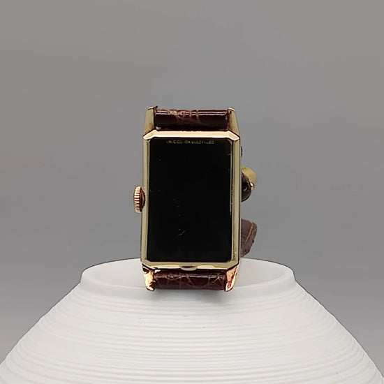 Longines Rectangular Art Deco 1948, montre vintage cadran champagne, mouvement manuel, vue détaillée sur fond.