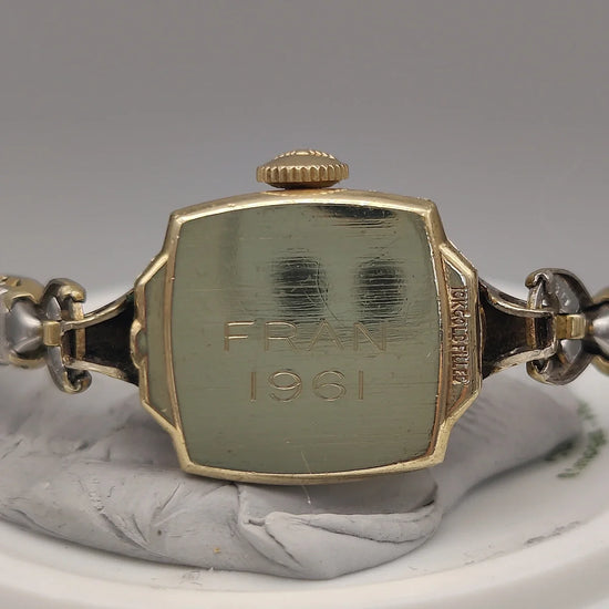 Longines Rectangular Dress Watch 1950, cadran crème, mouvement manuel, sur fond. Montre vintage Longines.