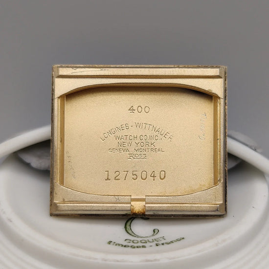 Photo de la montre Longines Vintage Square de 1955, cadran champagne, mouvement manuel, sur fond studio.