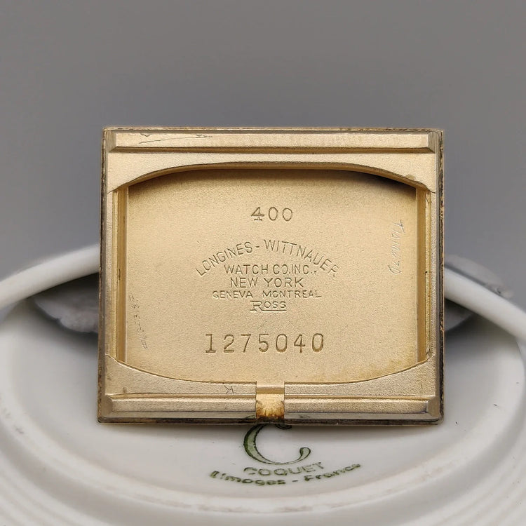 Photo de la montre Longines Vintage Square de 1955, cadran champagne, mouvement manuel, sur fond studio.