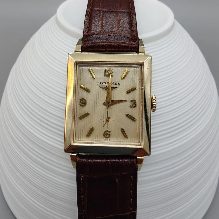 Cadran champagne détaillé d'une montre Longines Vintage Square de 1955, mouvement manuel. Élégance horlogère vintage.