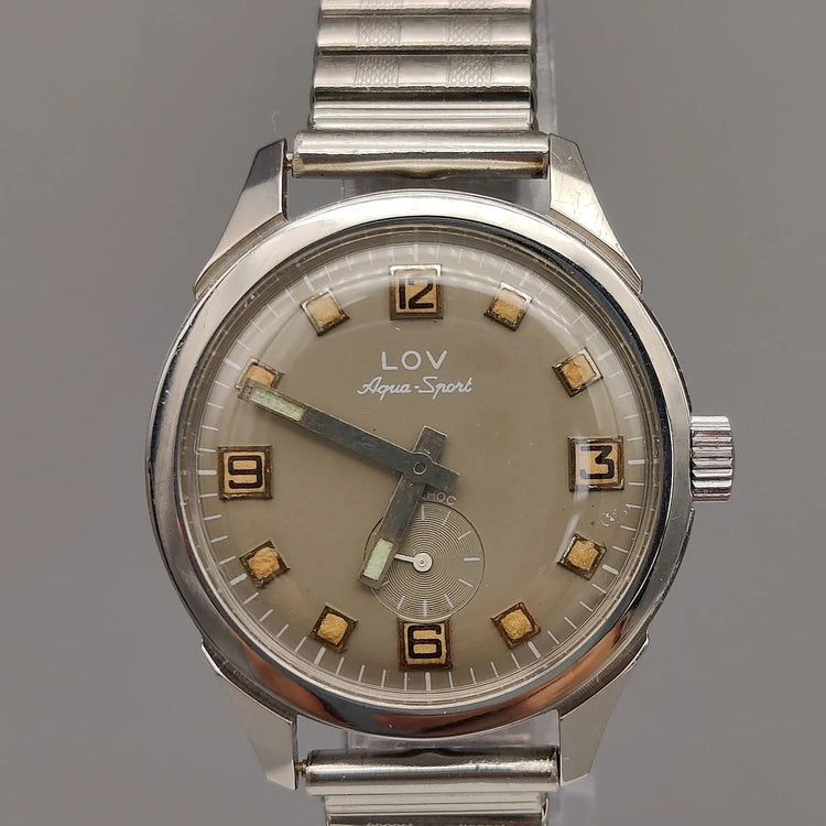 Vue boîtier Lov Aqua-Sport 1970, montre automatique vintage, cadran gris champagne. Élégance intemporelle.