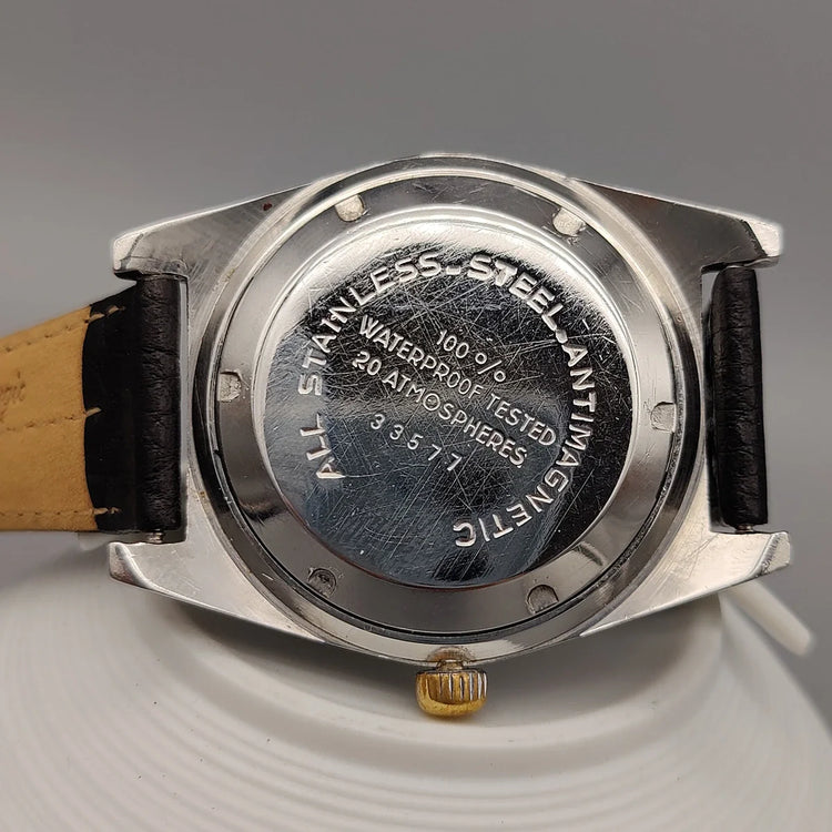 Montre vintage Lov Espadon 1970, cadran noir. Mouvement manuel. Photo sur fond neutre.