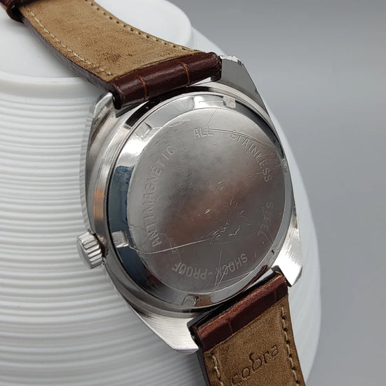 Photo d'une montre Oris Antichoc vintage 1970, cadran champagne, mouvement manuel, présentée sur fond épuré.