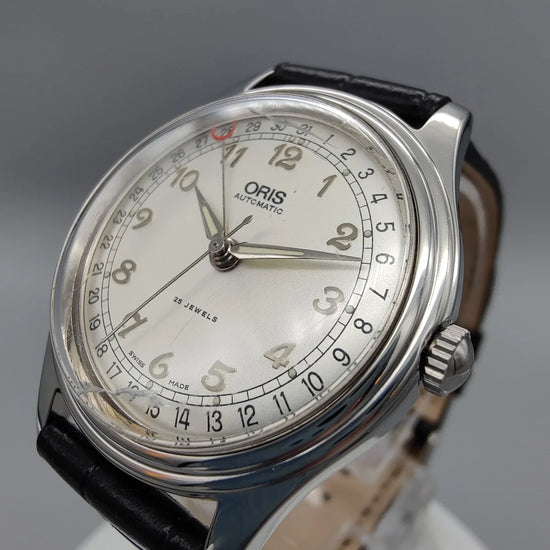 Oris Pointer-Date 1997 vintage, cadran crème, mouvement manuel. Détail de la lunette, parfait pour collectionneurs de montres vintage.