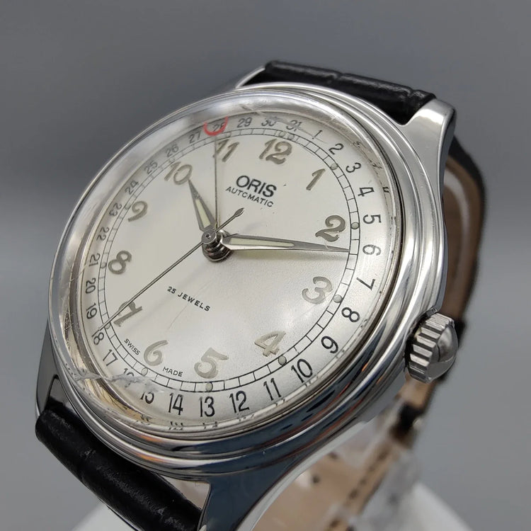 Oris Pointer-Date 1997 vintage, cadran crème, mouvement manuel. Détail de la lunette, parfait pour collectionneurs de montres vintage.
