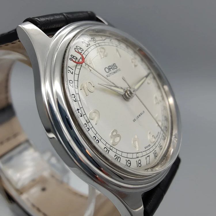 Montre vintage Oris Pointer-Date 1997, mouvement manuel, cadran crème. Vue détaillée du verre et de son état.