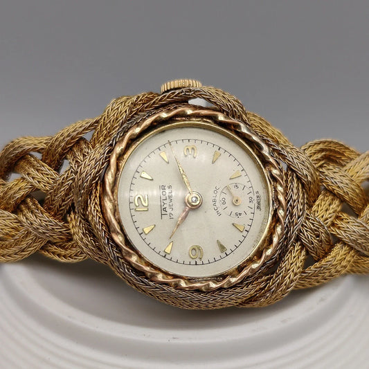 Boîtier montre vintage Taylor Incabloc 1955, mouvement manuel, cadran champagne. Vue détaillée pour collectionneurs.