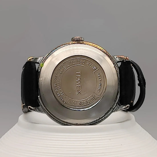 Montre automatique vintage Timex Automatic Water Resistant 1973, cadran champagne, sur fond. Élégance intemporelle.