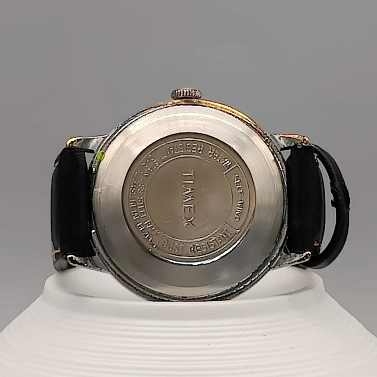 Montre automatique vintage Timex Automatic Water Resistant 1973, cadran champagne, sur fond. Élégance intemporelle.