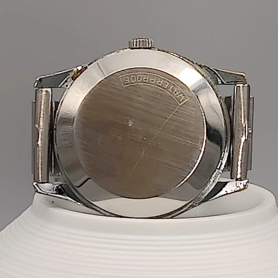 Montre vintage Tissot Visodate Camping 1962 automatique, cadran champagne, vue de fond.