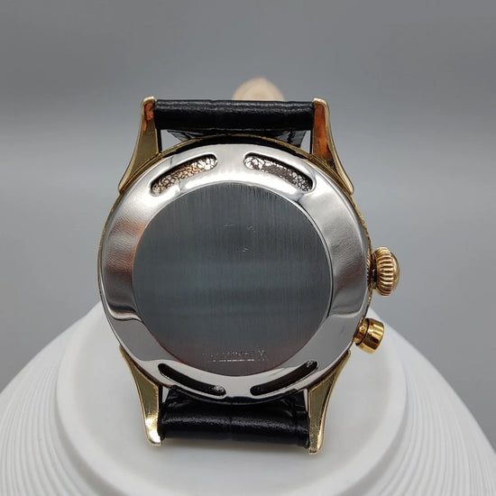 Montre vintage Vulcain Cricket de 1955 avec cadran champagne et mouvement manuel, présentée sur fond.