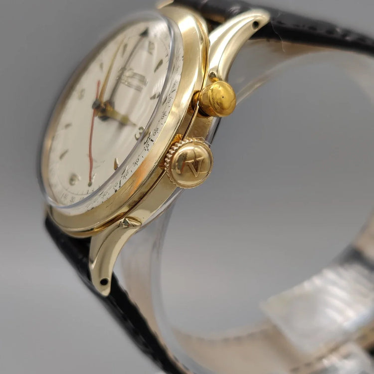 Couronne détaillée de la montre Vulcain Cricket vintage 1955, cadran champagne. Symbole d'une montre manuelle historique.